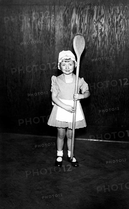 Girl with a large wooden spoon, 1930, A little girl in a costume proudly holds an oversized wooden spoon, Historical photo