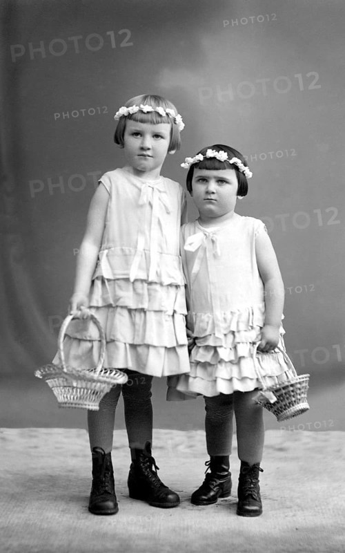 2 girls with wreaths of flowers, 1910, Two girls in dresses with baskets of flowers pose in a studio, Historical photo