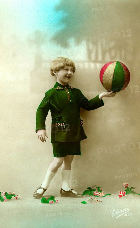Child with ball, 1910, Boy in a green suit playing with a colourful ball, historical photo