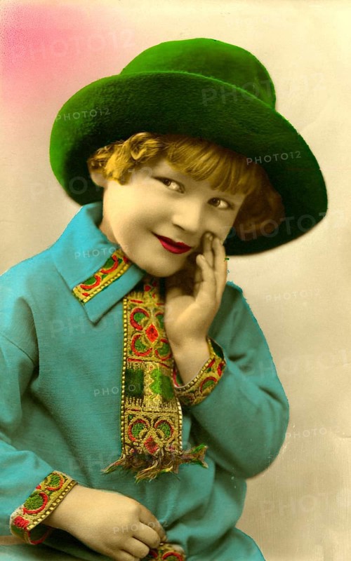 Girl with green hat, 1920, boy in green hat and blue shirt smiling and looking to the side, historical photo