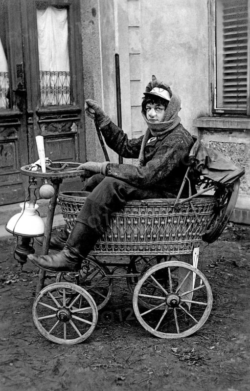 Disguised man in pram, 1920s, A woman in antique clothes drives an old-fashioned vehicle with four wheels, Historical photo