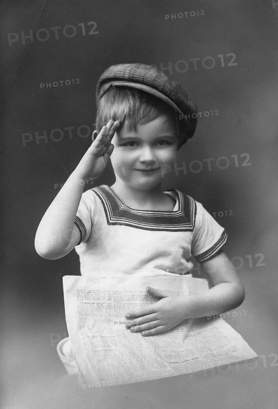 Little boy, 1920s, child with cap holding a newspaper and greeting, black and white photo with nostalgic flair, historical photo