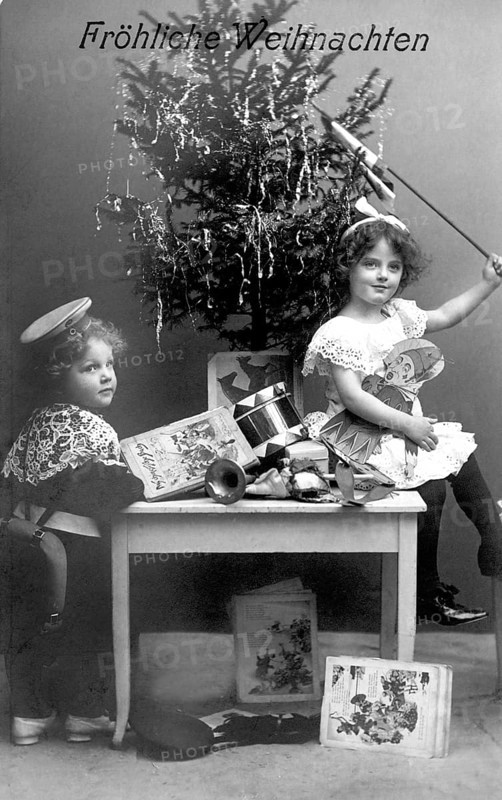 Boy and girl under a Christmas tree, 1930s, Two children sitting in front of a Christmas tree with presents and a joyful atmosphere, Historical photo