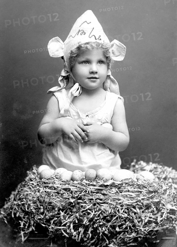 Child with Easter eggs, 1930s, Little girl in bunny costume sitting in a nest surrounded by eggs, Historical photo
