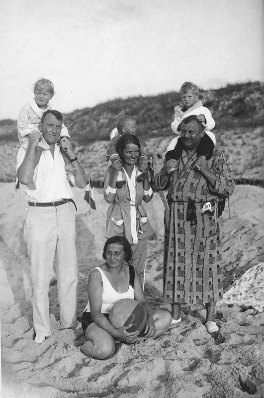 Family on the beach, 1920s, family photo on the beach with adults and children, children sitting on shoulders, nostalgic atmosphere, historical photo