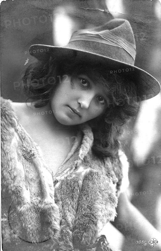 Child with animal fur, 1920s, woman with hat and fur dress looking into the camera, black and white portrait, historical photo