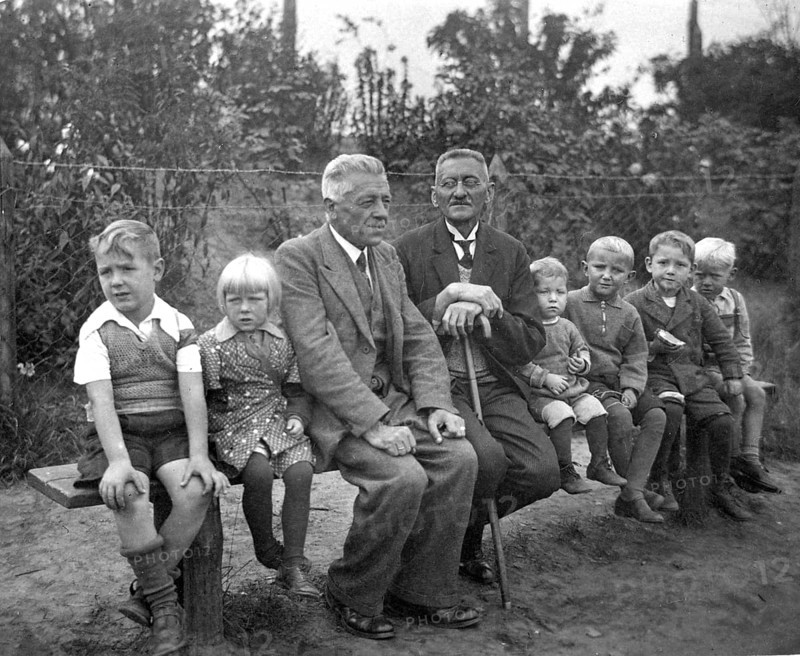 Short and tall men, 1920s, grandfather and children on an outdoor bench, symbolises family ties across generations, historical photo