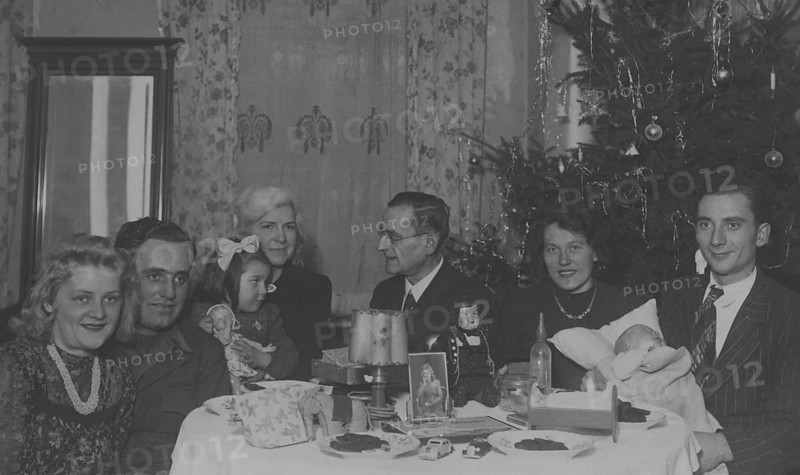 Christmas party, 1930s, Christmas party with a family around a set table with presents and a Christmas tree in the background, historical photo