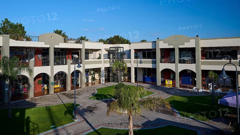 Modern shopping centre with arcades, green areas and balconies under sunny skies, Marina Centre, Kos Town, Kos, Dodecanese, Greek Islands, Greece