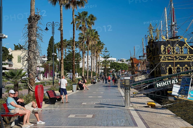 Promenade with palm trees and a sailing ship in the background, relaxed atmosphere, harbour promenade, Kos Town, Kos, Dodecanese, Greek Islands, Greece