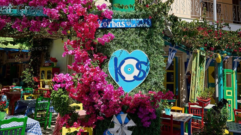 Colourfully decorated taverna with flowers and heart-shaped kos sign, sunny atmosphere, Platia Diagora, Kos Town, Kos, Dodecanese, Greek Islands, Greece