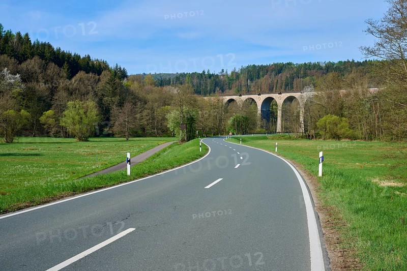 A winding road leads to a viaduct in a wooded landscape, spring, Obersinn, Sinntal, Spessart, Bavaria, Germany