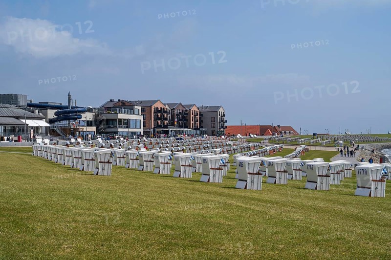 Beach chairs on the green beach, building on the promenade, Büsum, North Sea, Schleswig-Holstein, Germany