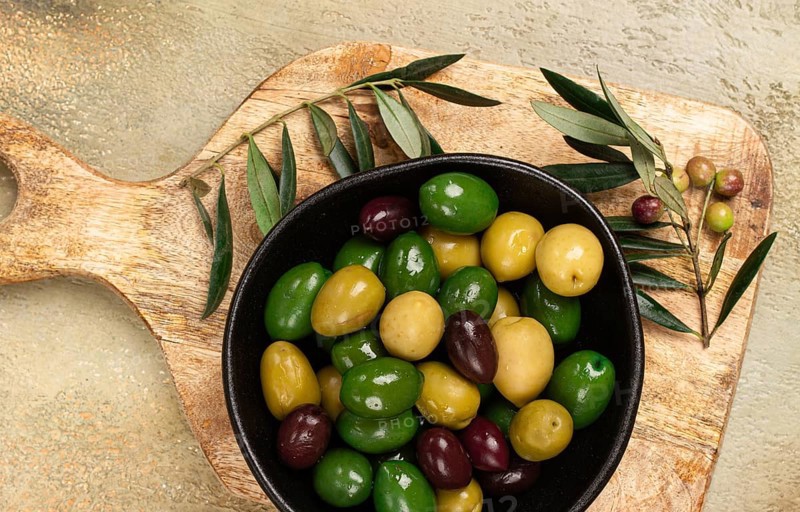 A mixture of olives, varieties of chalkidiki, Verdi giganti and Kalamata, in a bowl, top view, no people