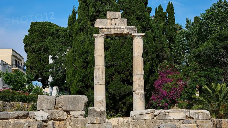 ©Udo Rein, Columned ruins against a backdrop of dense greenery and blossoming trees, Temple of Heracles, Ancient Agora, Kos Town, Kos, Dodecanese, Greek Islands, Greece