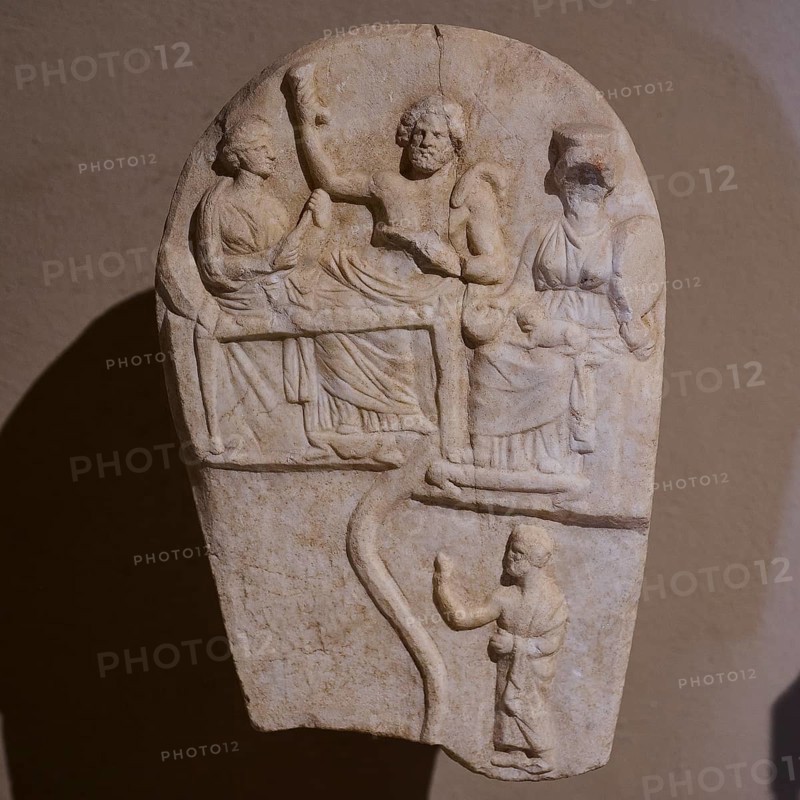 ©Udo Rein, Antique stone relief with several figures in scene, banquet of the dead, snake, Casa Romana, Kos Town, Kos, Dodecanese, Greek Islands, Greece