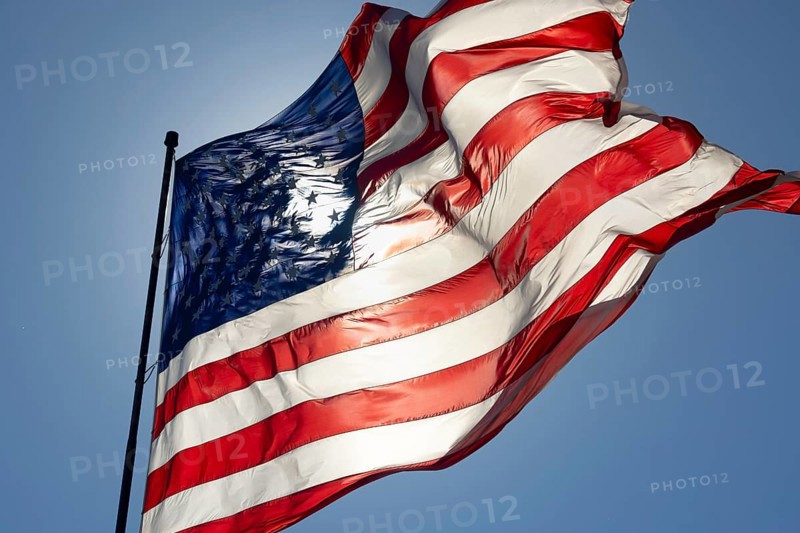 Dramatic backlit american flag waving in the wind