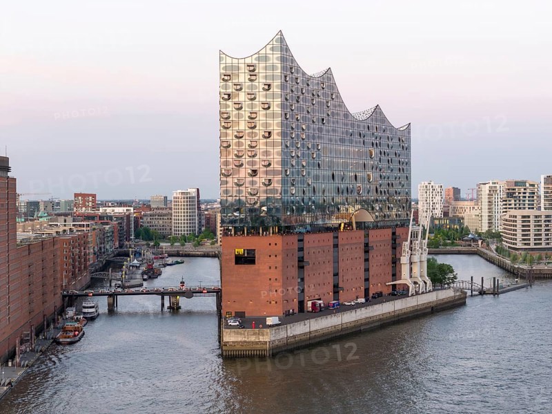 The Elbphilharmonie concert hall in Hamburg is reflected in the glass design above the historic Kaispeicher warehouse, Hamburg, Germany