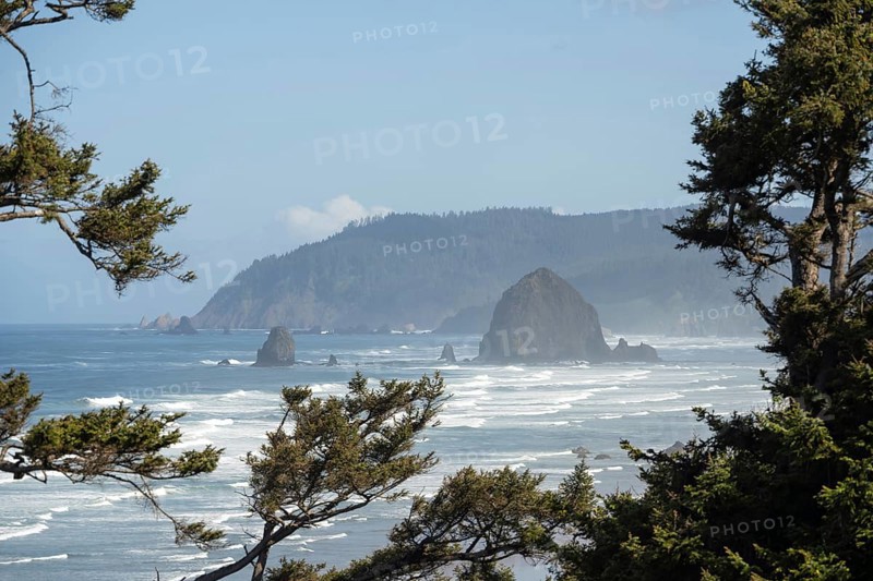 Sunny beach with large rocks in the sea and clear blue sky, peaceful and relaxing atmosphere, Haystack Rock, Cannon Beach, Oregon, USA, North America