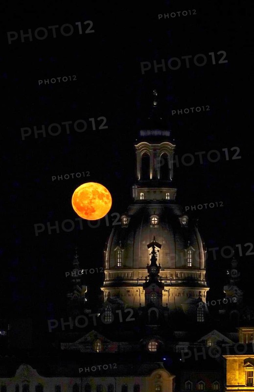 Glowing strawberry moon on 11 June 2025 next to the dome of the Church of Our Lady Dresden, Saxony, Germany