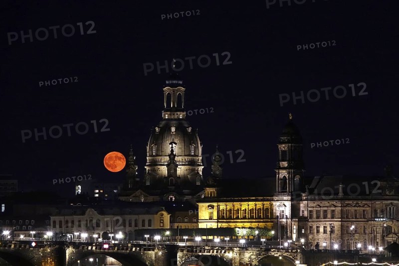 Glowing strawberry moon on 11 June 2025 over Augustus Bridge and Church of Our Lady Dresden, Saxony, Germany