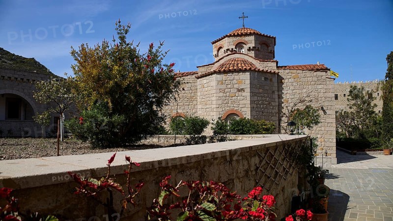 Stone church with tiled roof, surrounded by a blooming garden under a blue sky, woman's monastery, Evangelismou Monastery, Patmos, Dodecanese, Greek Islands, Greece