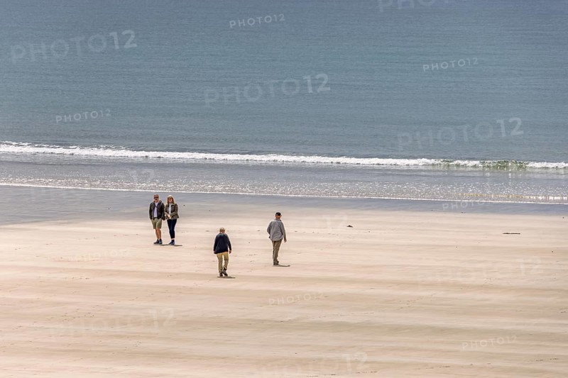 People walking on a sand beach by the sea a sunny summer day, Crozon peninsula, Bretagne, France