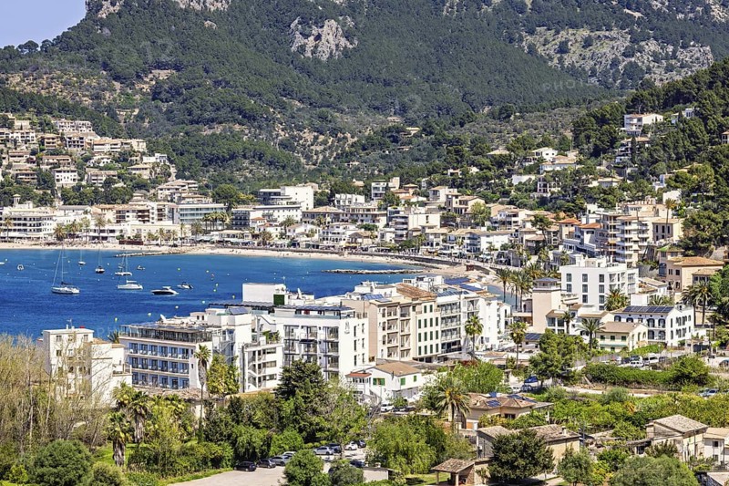 View at a tourist resort with houses by a seabay and mountains in the summer, Sant Elm, Mallorca, Spain
