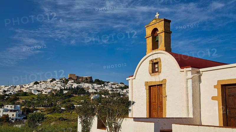 White chapel with cross and wooden door, village in the distance, chapel south of the Chora, World Heritage Site 1999, Chora, Patmos, Dodecanese, Greek Islands, Greece