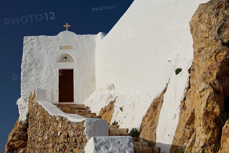 White church on rocky ground with stone steps and cross, under a blue sky, Church of the Prophet Elias, Profitis Ilias Chapel, Hermitage, Patmos, Dodecanese, Greek Islands, Greece