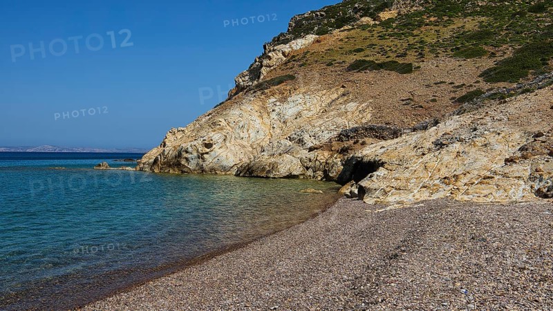 Stone beach under clear blue sky with coastline and water, Lambi Beach, Lambi Bay, Patmos, Dodecanese, Greek Islands, Greece