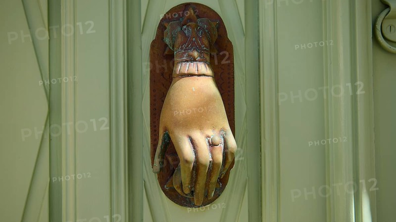Detail of an ancient, hand-shaped door knocker on a green door, Chora, UNESCO World Heritage Site 1999, Patmos, Dodecanese, Greek Islands, Greece