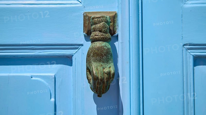 A metallic, hand-shaped door knocker on a blue door, depicted in detail, Chora, UNESCO World Heritage Site 1999, Patmos, Dodecanese, Greek Islands, Greece