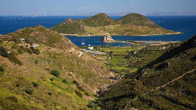 Hilly landscape with fields and coast, green and blue dominate the view, rocks of Kalikatsou, island of Tragonisi, Patoinos, organic viticulture, biodiversity garden, Patmos, Dodecanese, Greek Islands, Greece