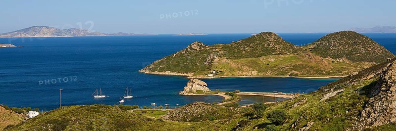 Panoramic view of sailing boats in front of mountains and a blue lake on an island, Rock of Kalikatsou, Seasonal Salt Lake, Tragonisi Island, Patmos, Dodecanese, Greek Islands, Greece