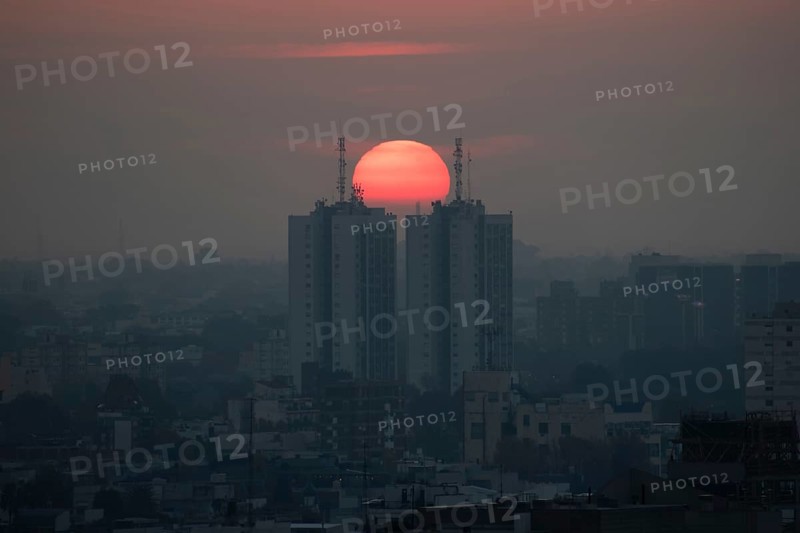 Sunset over skyscrapers in Buenos Aires, symmetry in photography, symbolic image for heat, global warming, climate change, environmental problems, smog, Buenos Aires, Argentina