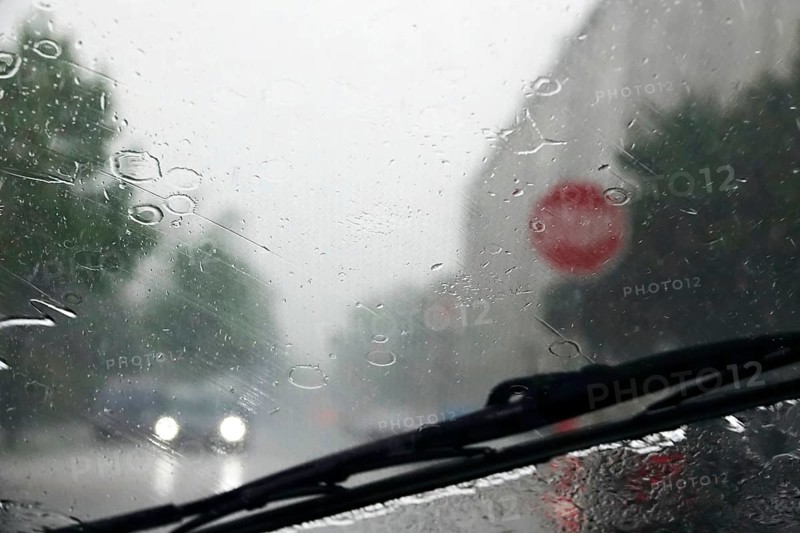 Driving a car in rainy weather, view through the windscreen, Germany