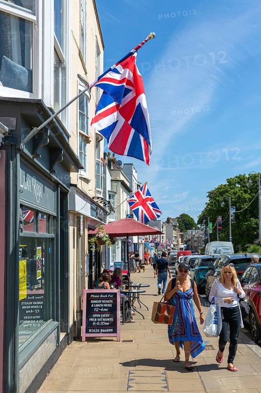 Union Jack flags on shops in street of historic buildings, The Strand, Dawlish, south Devon, England, UK