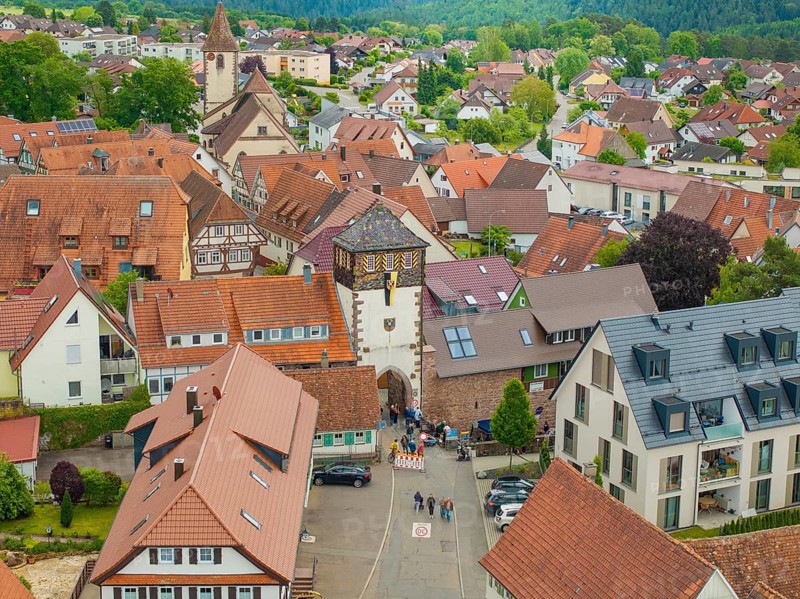 View of a picturesque village with half-timbered houses and a church, surrounded by green countryside, family party in Neubulach, district of Calw, Germany