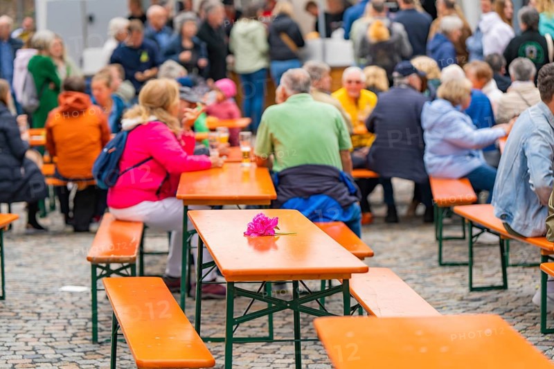 Outdoor event with beer tables and guests, one table is decorated with a pink flower, family party in Neubulach, district of Calw, Germany