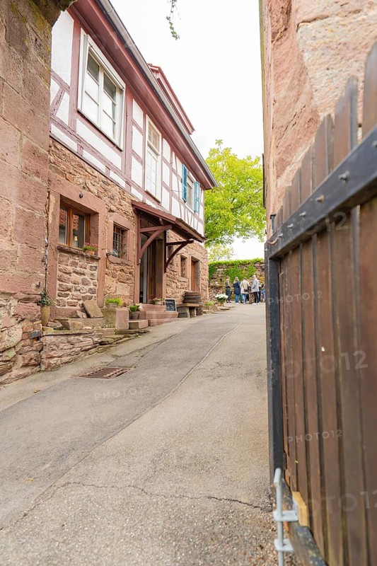 Narrow alley with traditional half-timbered houses and stone walls in a historic neighbourhood, family festival in Neubulach, district of Calw, Germany
