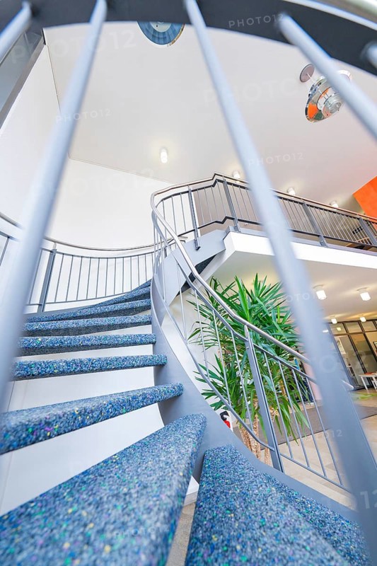 Modern spiral staircase with blue steps and a stylish banister in a bright interior, town hall, family celebration in Neubulach, district of Calw, Germany
