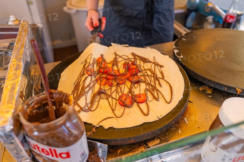 Preparation of a crepe with Nutella and strawberries in a lively kitchen, Calw railway station festival, Black Forest, Germany
