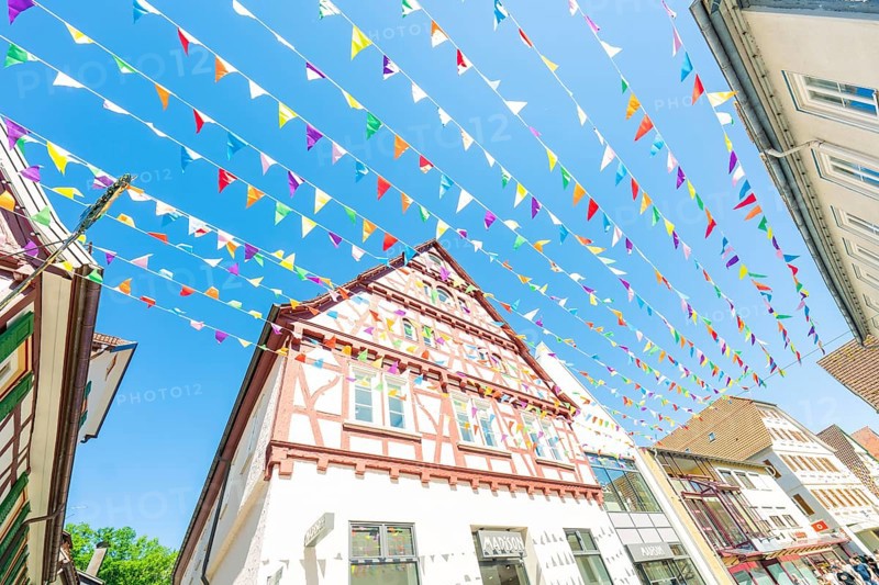 Colourfully decorated town with half-timbered houses and colourful flags in summer, Calw station festival, Black Forest, Germany