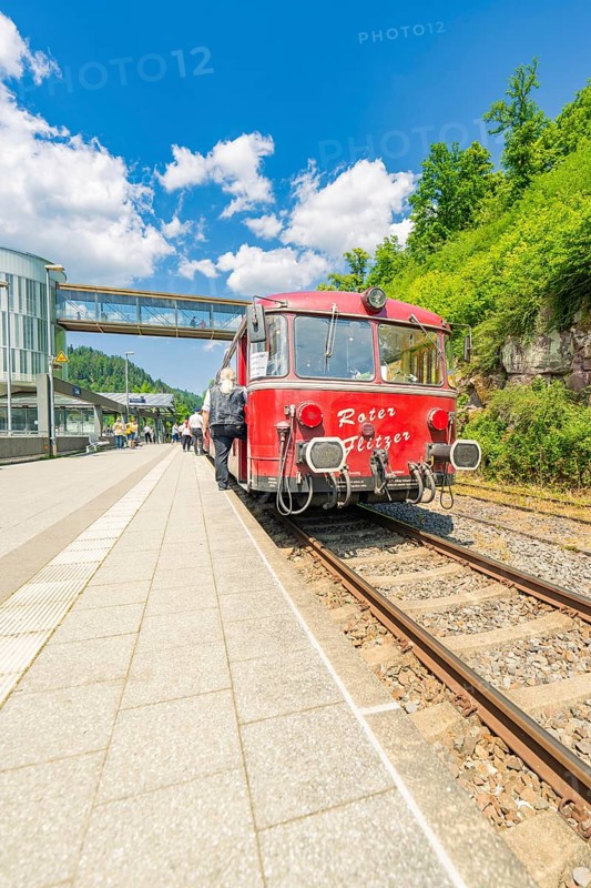Red train waiting on the track under a blue sky, Calw railway station festival, Black Forest, Germany