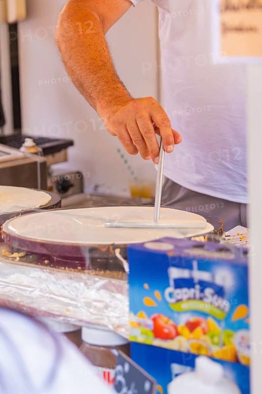 Person preparing crepe batter at a market stall, Calw railway station festival, Black Forest, Germany