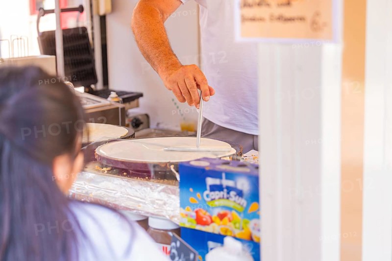 Man preparing crepes in a market stall with Capri-Sun in the background, Calw railway station festival, Black Forest, Germany