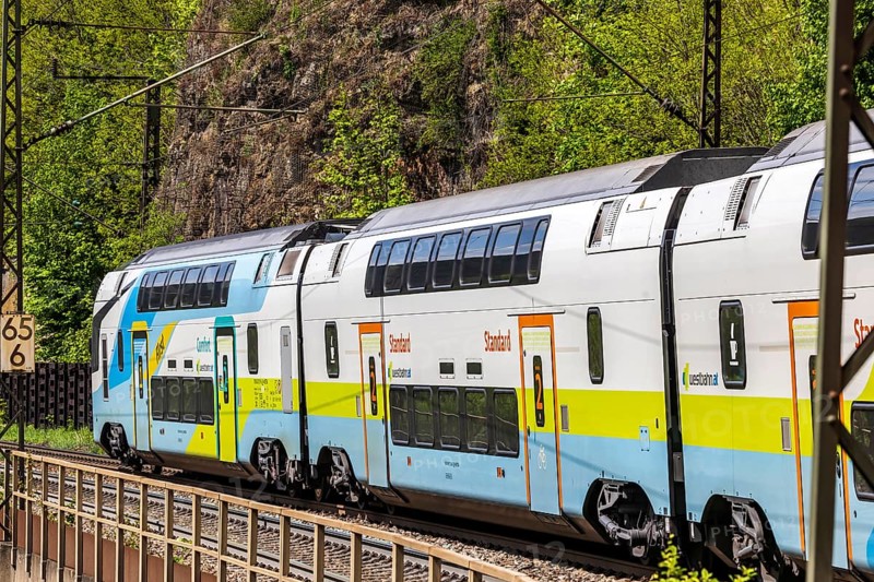 Train of the Austrian Westbahn en route on the winding railway line of the Geislinger Steige. Landscape on the railway's Filstalline line in spring. Amstetten, Baden-Württemberg, Germany