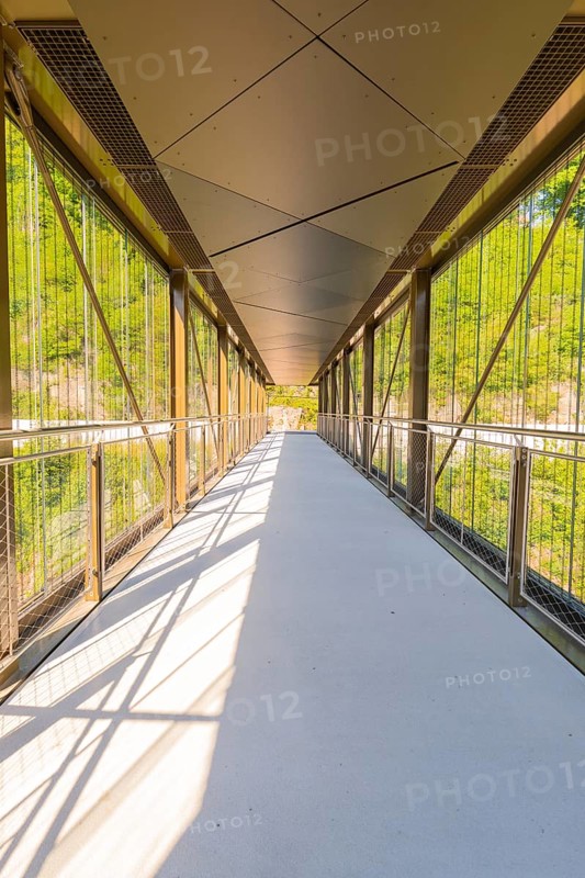 A modern glass and metal bridge with a shadow pattern in sunny weather, Zob extension with bridge construction for the new Herman Hesse railway, Calw, Black Forest, Germany