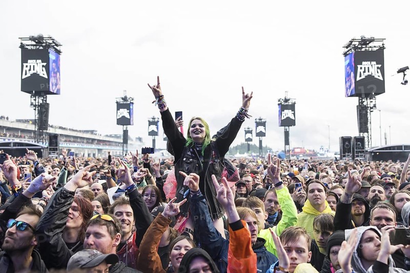 Festival visitor on shoulders with a French fries fork shaped like a hand at the Rock am Ring Festival on Friday, Nürburgring race track race track, 07.06.2025